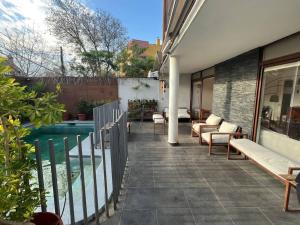 um pátio com cadeiras e uma piscina numa casa em Casa Oasis en Providencia em Santiago