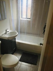 a bathroom with a sink and a tub and a toilet at Stylish Montreal Apartment: Comfortable Stay in the Golden Square Mile in Montreal