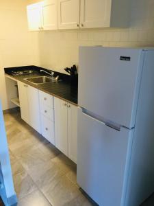 a kitchen with a white refrigerator and a sink at Stylish Montreal Apartment: Comfortable Stay in the Golden Square Mile in Montreal