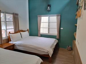 two beds in a room with blue walls and a window at 古都101民宿 適合2至7人包棟 in Tainan