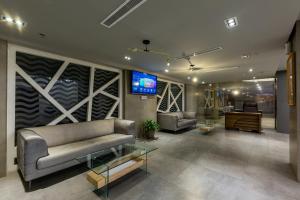 فندق روزالينا في ينبع: غرفة معيشة مع أريكة وتلفزيون على الحائط