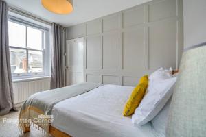 ein Schlafzimmer mit einem großen weißen Bett mit gelben Kissen in der Unterkunft Sunnyside, Kingsand in Kingsand