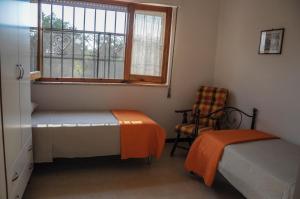 sypialnia z 2 łóżkami, oknem i krzesłem w obiekcie Residence Sunbeam w mieście Leporano Marina +33 zdjęcia