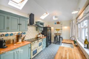 a kitchen with blue cabinets and a counter top at Sunnyside, Kingsand in Kingsand