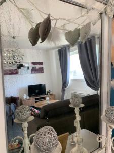 a living room with a couch and a mirror at Bienvenue à la maison in Étaples
