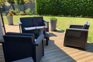 a patio with three chairs and a table and a couch at Bienvenue à la maison in Étaples