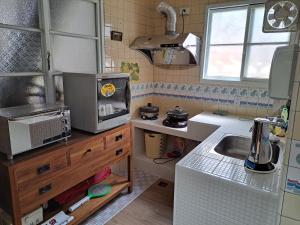 a small kitchen with a sink and a microwave at 古都101民宿 適合2至7人包棟 in Tainan