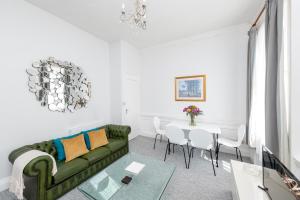 - un salon avec un canapé vert et une table dans l'établissement Super City Centre Apartment - two bedrooms, perfect location, à Bath