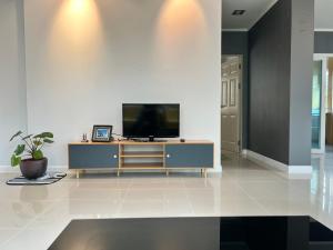 a living room with a television on a cabinet at Happy home บ้านกว้าง ได้ทั้งหลัง ไวไฟฟรี1000Mbps ใกล้สนามบินสุวรรณภูมิ in Min Buri