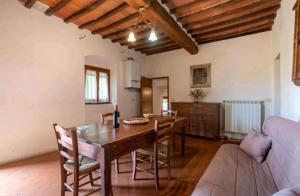een eetkamer met een tafel en stoelen en een bank bij Tenuta La Cella - Grande Appartamento in Arezzo