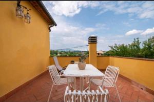 een patio met een tafel en stoelen op een balkon bij Tenuta La Cella - Grande Appartamento in Arezzo