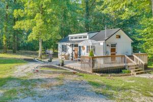 New Johnsonville的住宿－Modern Camden Villa with Deck, Near Tennessee River，树林中的一个小房子,有门廊