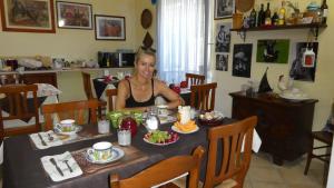 a woman sitting at a table with a plate of food at B&B Oliena in Oliena