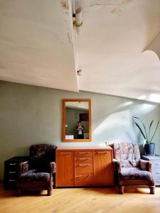 sala de estar con 2 sillas y espejo en Polonia Tbilisi House, en Tiflis