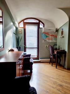 sala de estar con mesa, sillas y escritorio en Polonia Tbilisi House, en Tiflis