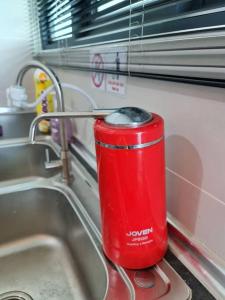 uma lata vermelha está sentada num lavatório da cozinha em V' BROS Viva Funstay J4.1 [GOT DRYER] em Kuching