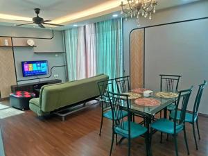 een woonkamer met een tafel en stoelen en een bank bij V' BROS Viva Funstay J4.1 [GOT DRYER] in Kuching