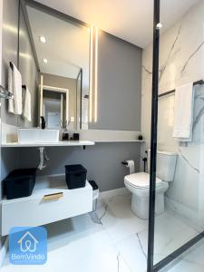 a bathroom with a toilet and a sink and a mirror at Apartamento Completo e Aconchegante no Centro in Salvador
