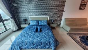 ein Schlafzimmer mit einem Bett mit einer blauen Bettdecke in der Unterkunft MHA 26 EVO SUITE SOHO BANDAR BARU BANGI FREE NETFLIX N WIFI in Bandar Baru Bangi