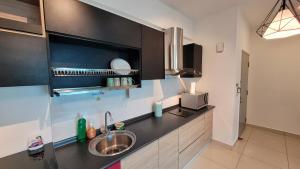 eine Küche mit Spüle und Mikrowelle in der Unterkunft MHA 26 EVO SUITE SOHO BANDAR BARU BANGI FREE NETFLIX N WIFI in Bandar Baru Bangi