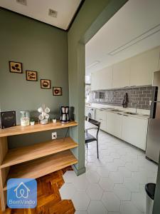uma cozinha com armários brancos, uma mesa e uma cadeira em Apartamento Completo e Aconchegante no Centro em Salvador