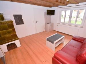 sala de estar con sofá rojo y mesa en Haus Kornblume en Colmberg