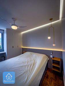 a bedroom with a bed and two lights on the wall at Apartamento Completo e Aconchegante no Centro in Salvador