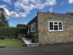 a stone house with a white window and a yard at Crown & Anchor in Grantham
