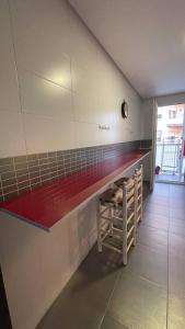 una cucina con bancone rosso in una camera di Preciosa a 2 min Renfe a Gandía