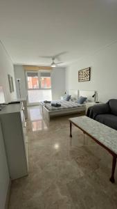 ein Wohnzimmer mit einem Sofa und einem Bett in der Unterkunft Preciosa a 2 min Renfe in Gandía