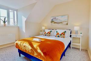 1 dormitorio con 1 cama grande con manta naranja en Super Quiet 4 Bed Family House in Gravesend, en Kent