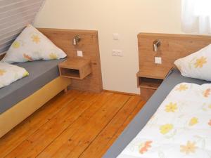 1 Schlafzimmer mit 2 Betten und Holzboden in der Unterkunft Libelle in Colmberg