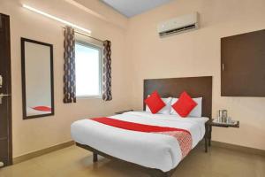 um quarto com uma cama grande e almofadas vermelhas em OYO Flagship ELEGANT RESIDENCY em Chennai