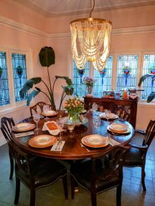 uma sala de jantar com uma mesa com cadeiras e um lustre em Inn at Rose Hall em Eureka Springs