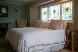 una camera da letto con letto, lenzuola bianche e finestre di Inn at Rose Hall a Eureka Springs
