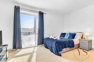 a bedroom with a bed and a large window at Riverside Apartment 2BR - Parking - Wi-Fi -Netflix in Derby