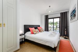 a bedroom with a bed with red pillows and a window at Marina Real 2391 in Manilva +25 photos