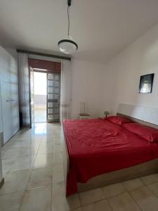 a bedroom with a red bed in a room at VILLA SALENTU LU SULE LU MARE LU IEUNTU in Torre Rinalda