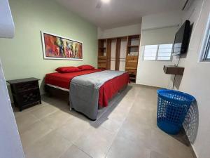 1 dormitorio con 1 cama con edredón rojo en Hermosa casa, en Playa del Carmen