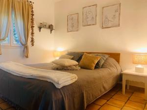um quarto com uma cama com duas almofadas em La Pitchoune : Gîte aux pieds des Alpilles em Mouriès