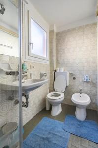 a bathroom with a toilet and a sink and a mirror at Appartamento Pescherie - Top location in Bologna +3 photos