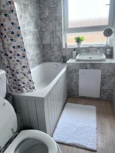 ein Badezimmer mit einer Badewanne, einem WC und einem Waschbecken in der Unterkunft Parsonage Leys in Harlow