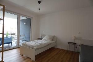 een witte slaapkamer met een bed en een balkon bij Ganzes Apartment -Paris- in Erftstadt - 3 Zimmer & 77qm - nahe Köln, Messe, Phantasialand & Bonn - Familienurlaub oder Business Trip in Erftstadt