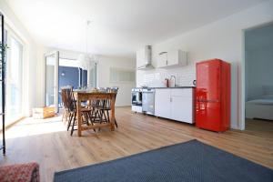 een keuken met een tafel en een rode koelkast bij Ganzes Apartment -Paris- in Erftstadt - 3 Zimmer & 77qm - nahe Köln, Messe, Phantasialand & Bonn - Familienurlaub oder Business Trip in Erftstadt