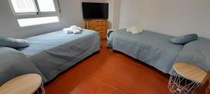 a room with two beds and a tv in it at La Huella del Peregrino in Palas de Rei 