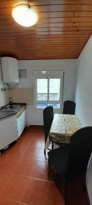 a kitchen with a table and chairs in a room at La Huella del Peregrino in Palas de Rei