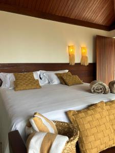 Kuarasy Boutique Hotel Japaratinga في جاباراتينغا: غرفة نوم بسرير ابيض كبير مع مخدات
