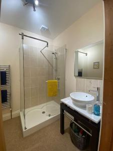 La salle de bains blanche est pourvue d'un lavabo et d'une douche. dans l'établissement 5A - ‘Your Place’ A Unique Space to make your own., à Elloughton