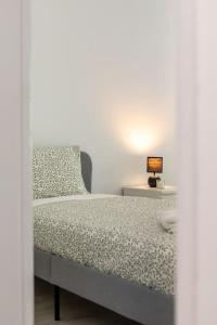 a bedroom with a bed with a lamp on a table at Massamá 26 / free park on premises/ smart TV in Queluz