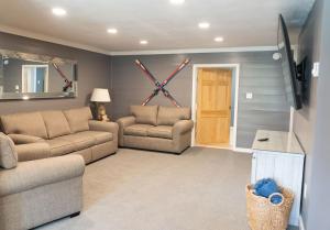 a living room with two couches and a tv at Ski Jump Chalet in Lake Placid
